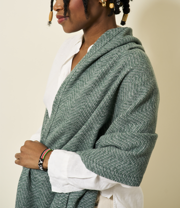Evergreen herringbone shawl draped over woman's shoulders, worn open over white shirt.6