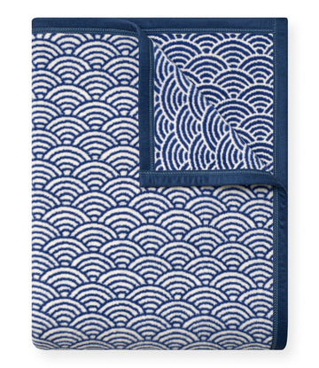 Blue blanket with scallop shell pattern in white, folded to show repeating design on both sides.5