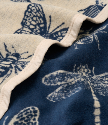 Cream and navy blanket with butterfly print, folded edge showing white binding detail.5