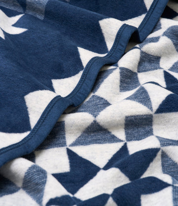 Navy and white quilted blanket with star pattern and blue binding detail.9