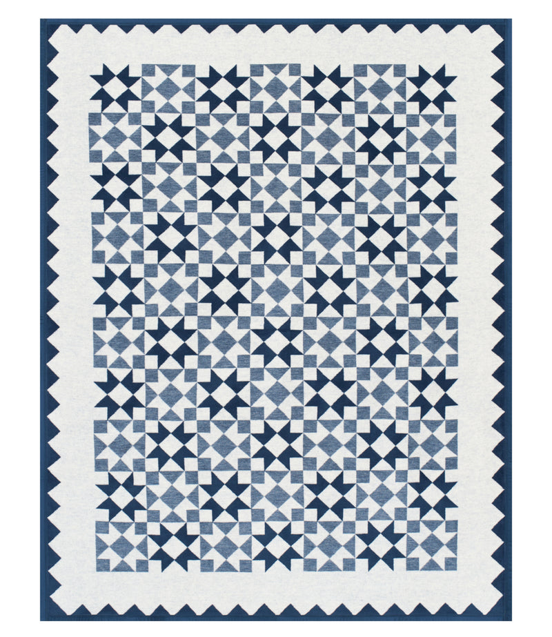 Navy and cream quilt blanket with geometric star and diamond pattern and scalloped edges.