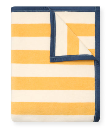 Folded blanket with alternating yellow and cream horizontal stripes and navy blue binding around edges.6