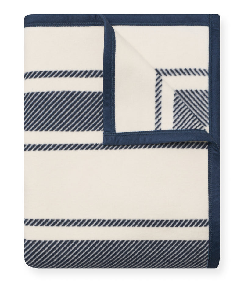 Navy and cream striped blanket with diagonal pattern details and navy binding along edges.