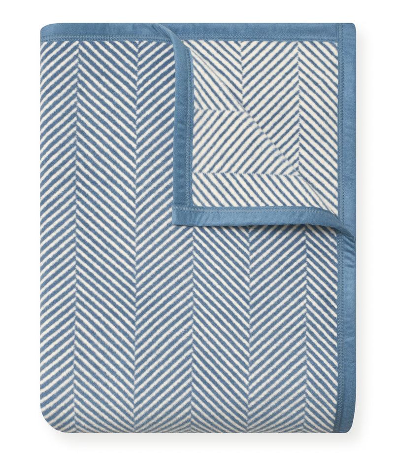 Cornflower blue blanket with white herringbone pattern and solid blue border.