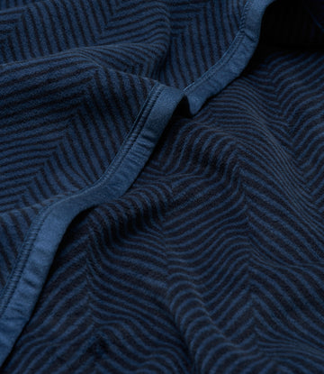 Dark blue blanket with herringbone weave pattern and bound edges, shown folded.7