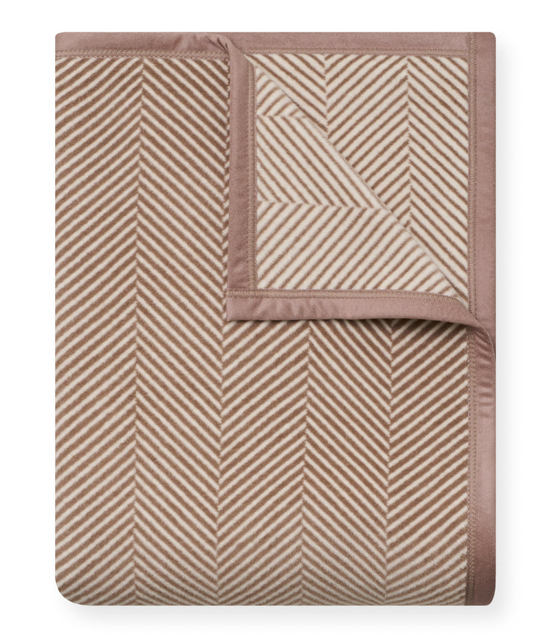 Folded sepia and cream blanket with herringbone pattern and solid-colored border.