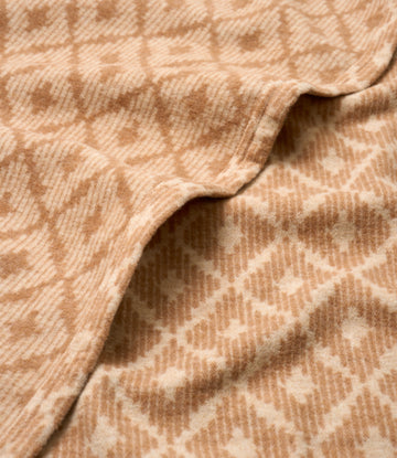 Tan and cream lightweight blanket with textured weave pattern and folded edges.4