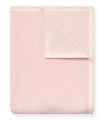 Ballet pink blanket with white herringbone pattern and cream binding, displayed folded.1