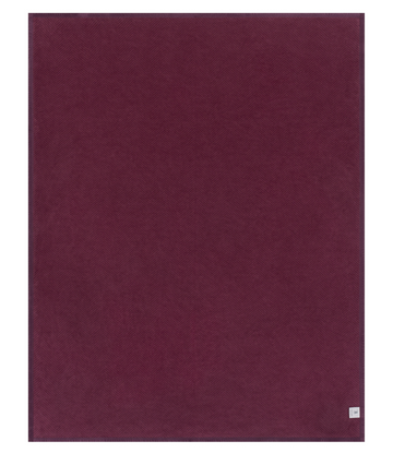 Plum-colored blanket with herringbone weave pattern and small label at bottom corner.7
