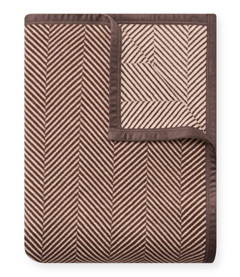 Brown and cream herringbone patterned blanket with chocolate brown binding, shown folded.