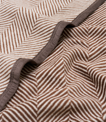 Brown and cream herringbone patterned blanket with dark gray binding along the edge.5