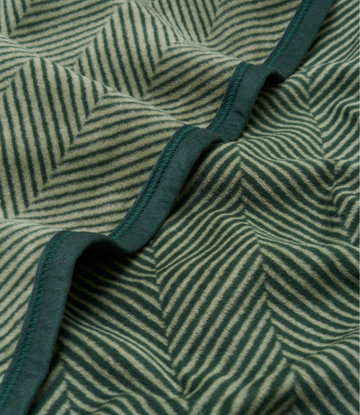 Forest green blanket with herringbone pattern and dark teal binding along the edge.5