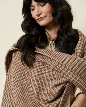 Woman wearing a chocolate brown plaid woven shawl draped across shoulders.6
