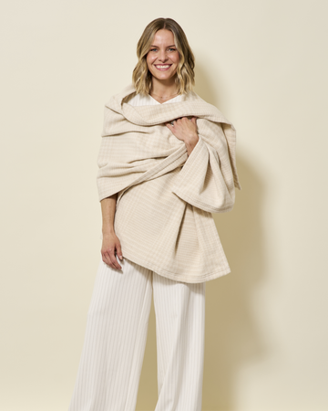 Woman wearing oatmeal plaid shawl draped over shoulders with white ribbed knit sweater and pants.3
