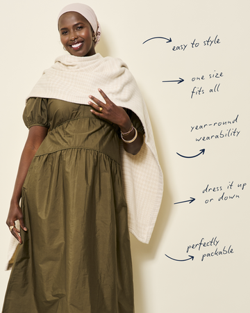 Oatmeal-colored plaid shawl draped over woman's shoulders and across body.2