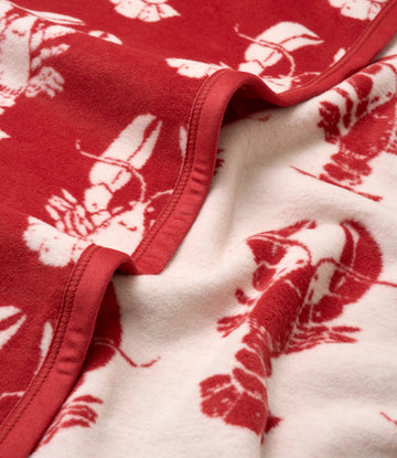 Red and cream blanket with lobster pattern and bound edge detail.7