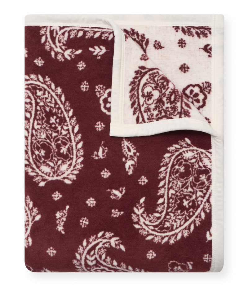 Burgundy and cream blanket with reversible paisley and floral jacquard pattern, folded to show both sides.