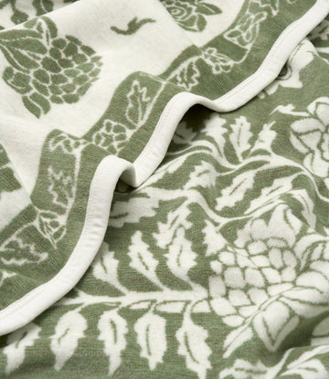 Sage green and cream blanket with white binding, featuring botanical tree and leaf pattern throughout.5